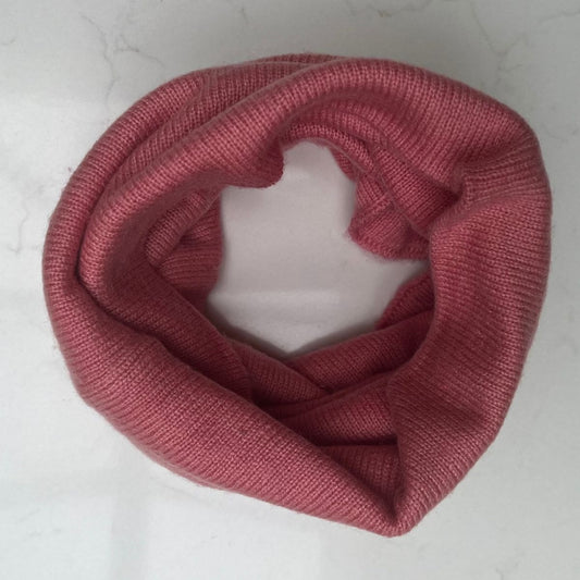 Pink cashmere snood shown as it would be worn, on a light gray background
